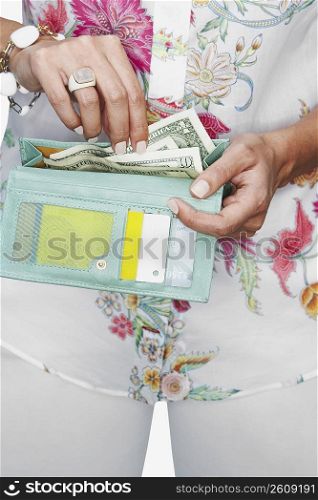Mid section view of a woman taking money from her wallet