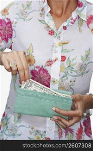Mid section view of a woman taking out one dollar bill from her purse