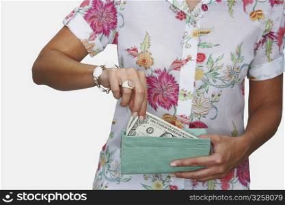 Mid section view of a woman taking out one dollar bill from her purse