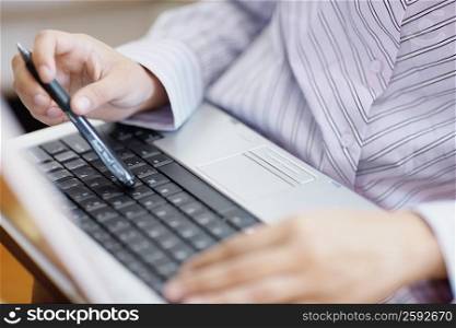 Mid section view of a woman using a laptop