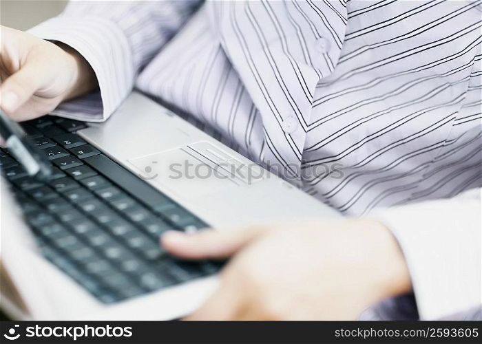Mid section view of a woman using a laptop