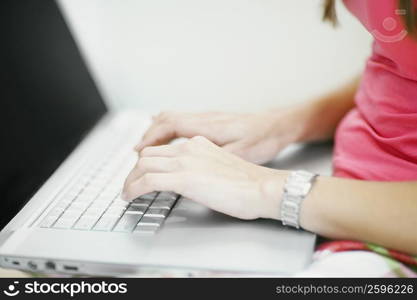 Mid section view of a woman using a laptop