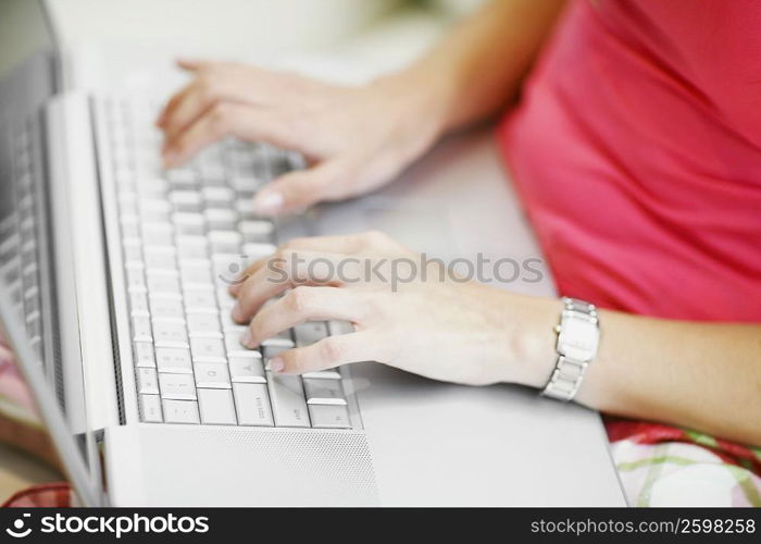 Mid section view of a woman using a laptop