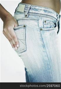 Mid section view of a woman with her hand in her jeans pocket