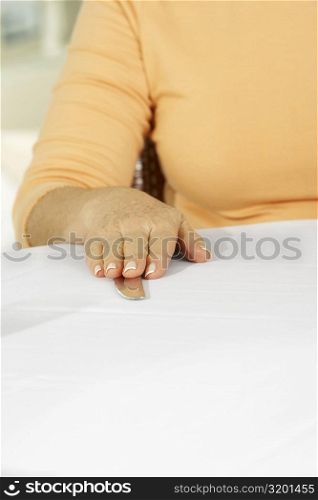 Mid section view of a woman with her hand on a table knife