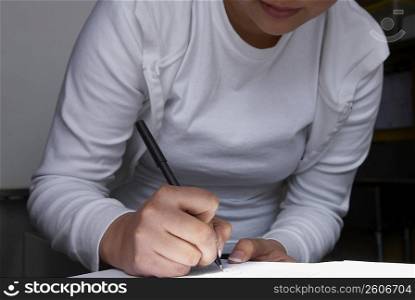 Mid section view of a woman writing