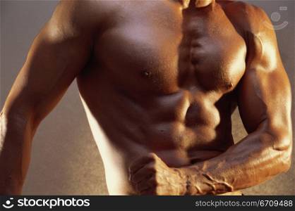 Mid section view of a young man flexing his muscles