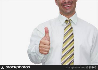 Mid section view of a young man making a thumbs up sign