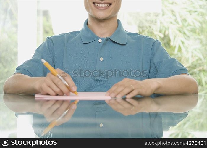 Mid section view of a young man sitting at a conference table and smiling
