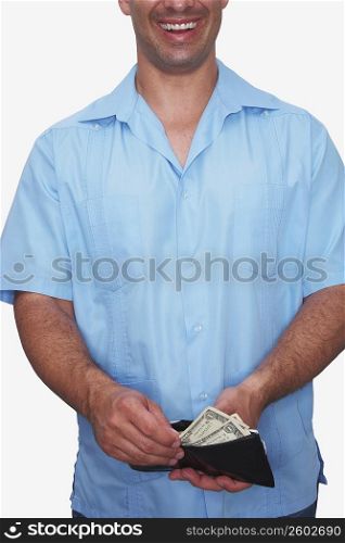 Mid section view of a young man taking out money from a wallet