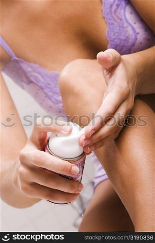 Mid section view of a young woman holding a bottle of moisturizer