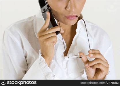 Mid section view of a young woman talking on a mobile phone