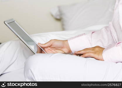 Mid section view of a young woman using a laptop