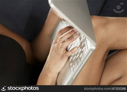 Mid section view of a young woman using a laptop