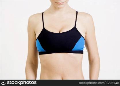 Mid section view of a young woman wearing a sports bra
