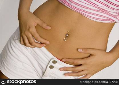 Mid section view of a young woman with a pierced belly button