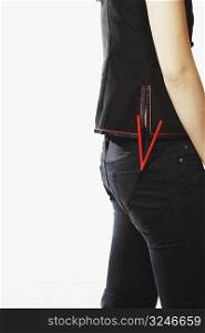 Mid section view of a young woman with chopsticks in her pockets