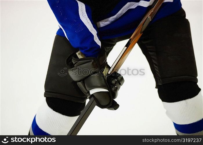Mid section view of an ice hockey player playing ice hockey