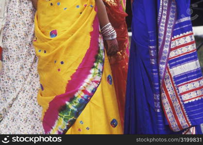 Mid section view of four women standing together