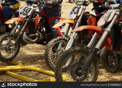 Mid section view of motocross riders on their motorcycles