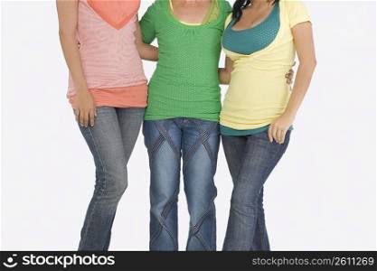 Mid section view of three women standing together
