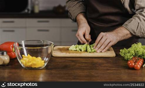 mid shot chef cutting salad