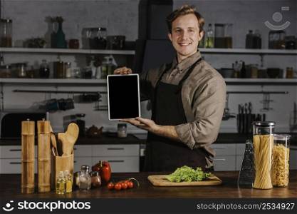 mid shot chef showing blank tablet