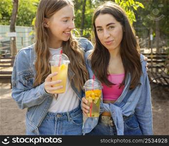 mid shot friends holding fresh juice 2