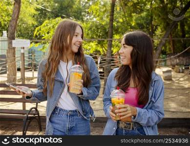 mid shot girls holding fresh juice