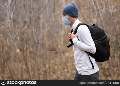 mid shot male with face mask backpack woods