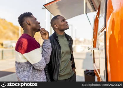 mid shot males reading food truck menu