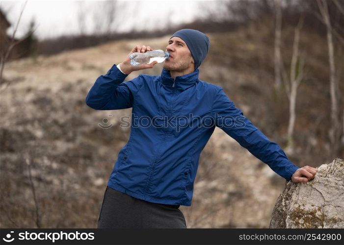 mid shot man drinking water nature