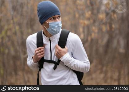 mid shot man with face mask backpack woods