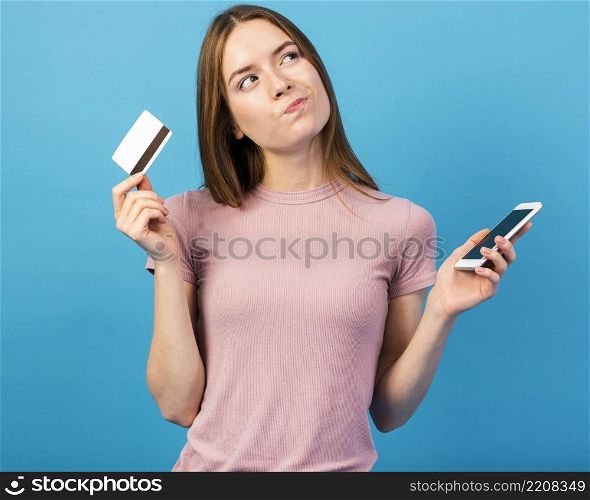 mid shot woman holding credit card phone looking away