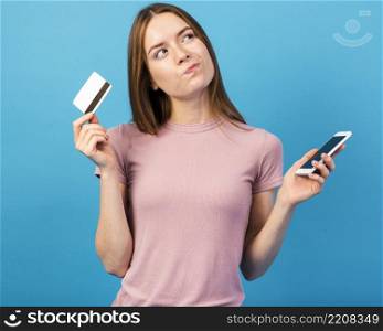 mid shot woman holding credit card phone looking away