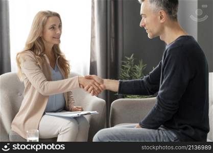mid shot woman therapist shaking hands with patient
