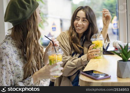 mid shot women with fresh drinks talking cafe