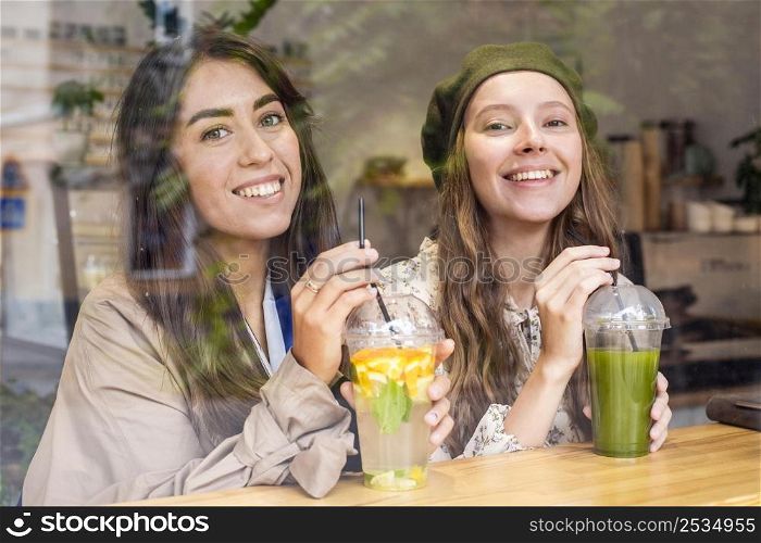 mid shot women with fresh juices cafe