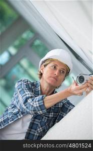 middl-age woman wearing a helment while doing diy