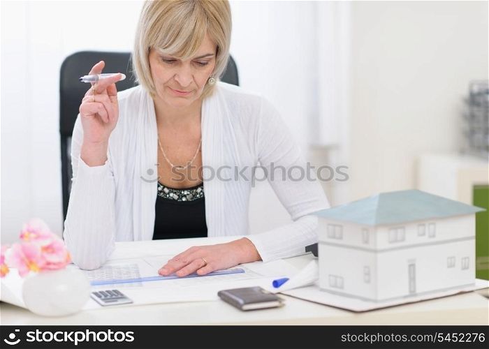 Middle age architect woman working on plans