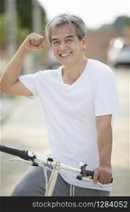 middle age asian man toothy smiling face happiness emotion exercise by riding bicycle in home village street