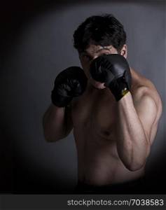 middle age boxer amateur trains on a dark background. boxing man
