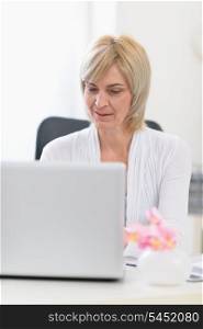Middle age business woman working on laptop