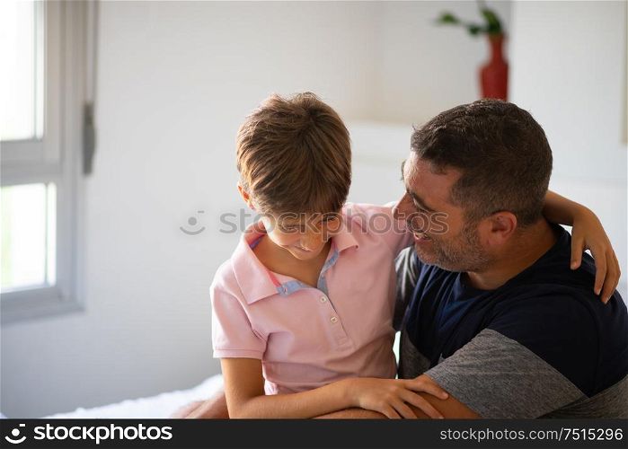 Middle-age father and her little daughter having fun at home. Man spending free time with her daughter.. Middle-age man and her little daughter are hugging.