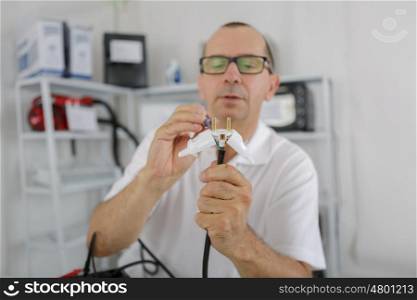middle-age man fixing a metal instrument