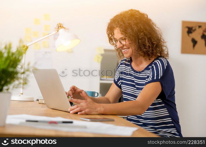 Middle age woman at the office working with a  laptop