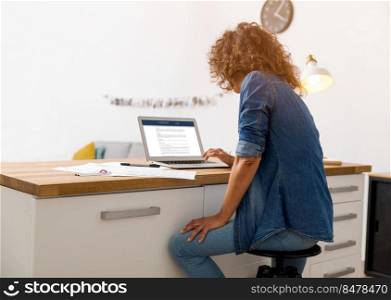 Middle age woman at the office working with a  laptop