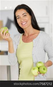 middle age woman is holding an apples