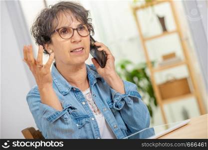 Middle age woman with glasses happy talking using a phone