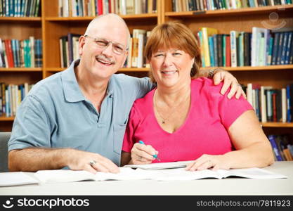 Middle aged adult education students studying in the library.